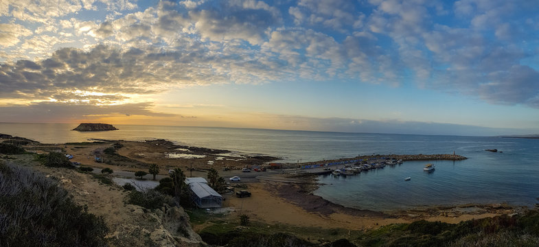 Wide panorama of sunset at Agios Georgios Fishing harbor. Paphos