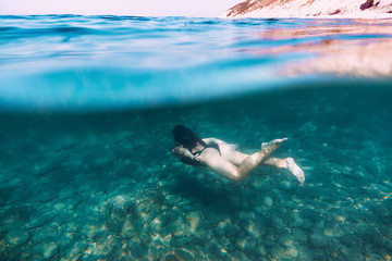 Slim woman dive underwater in blue sea. Active holidays