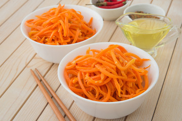 Spicy korean carrot calad in white plates