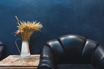 Vintage furniture and decoration, Dark blue wall with part of vintage leather armchair and vase...