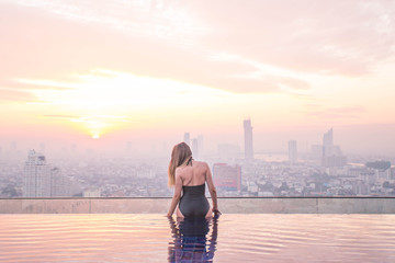 Tourist enjoing the sunrise city view from the root top. Thailang, Bangkok.