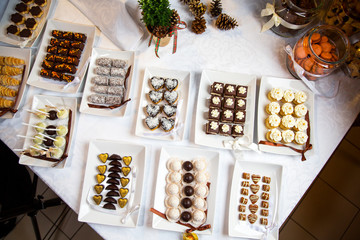 Kompozycja na stole z kolorowymi ciasteczkami i różnymi słodyczami przygotowanymi dla gości - obrazy, fototapety, plakaty