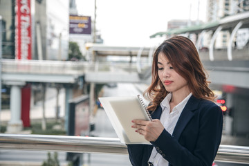 Fototapeta premium Portraits of beautiful asian woman look confidence is standing and writing a note while working.