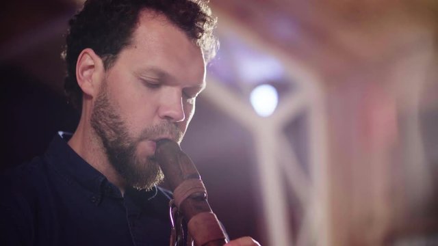 Close up portrait of musician playing ethnic flute