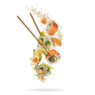 Flying pieces of sushi with wooden chopsticks, separated on white background.