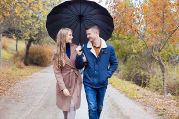 a guy with a girl go under umbrella rain