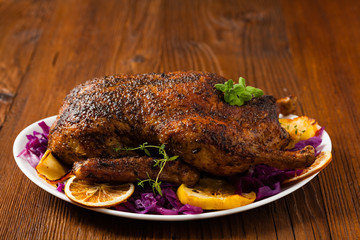 Baked whole duck, served with apples, red cabbage, oranges and roasted fritters.