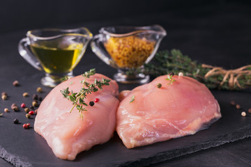 Raw chicken fillets with spices and herbs.