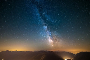 Milky Way and starry sky captured at high altitude in summertime on the Alps with glowing Aosta...