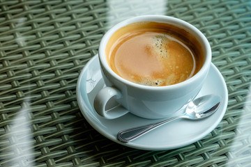 Hot coffee in a glass of coffee on a glass table.