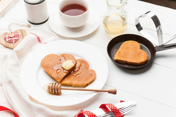 heart shaped pancakes on a light background. the concept of a festive breakfast for Valentine's Day or a pleasant surprise for a loved one