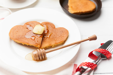 heart shaped pancakes on a light background. the concept of a festive breakfast for Valentine's Day or a pleasant surprise for a loved one