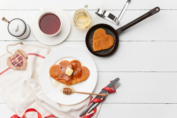 heart shaped pancakes on a light background. the concept of a festive breakfast for Valentine's Day or a pleasant surprise for a loved one