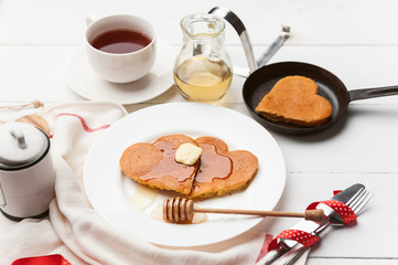 heart shaped pancakes on a light background. the concept of a festive breakfast for Valentine's Day or a pleasant surprise for a loved one