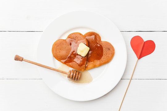 heart shaped pancakes on a light background. the concept of a festive breakfast for Valentine's Day or a pleasant surprise for a loved one