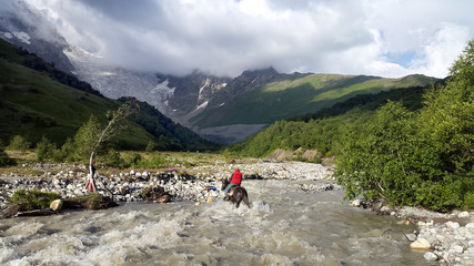 Fototapeta na wymiar Horsman crossing the glacier river