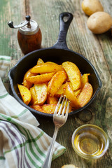 Potatoes with herbs and sesame seeds in a frying pan.