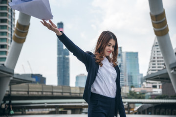 Fototapeta premium Portraits of beautiful asian woman look cheerful and confidence is standing and holding paper work while feeling success with work.