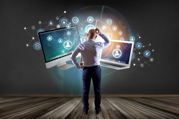 Businessman in front of a wall with computer and devices displayed on a futuristic interface with...