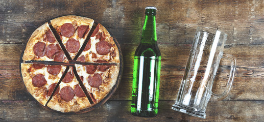 Pizza à la bière et au pepperoni sur une table en bois dans un pub ou une pizzeria