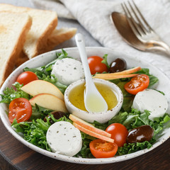 Fresh, delicious goat's cheese salad with lettuce, cherry tomatoes, Apple, Kalamata olives and a dressing of olive oil and toasted bread. square picture
