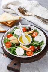 Fresh, delicious goat's cheese salad with lettuce, cherry tomatoes, Apple, Kalamata olives and a dressing of olive oil and toasted bread
