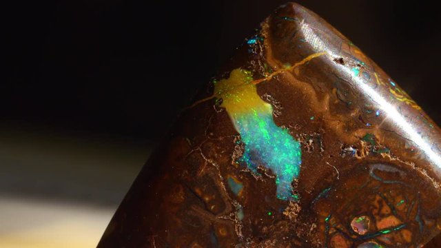 CLOSE UP: Stunning textured piece of rare Opal gemstone glistening under bright light. Beautiful multicolour mineraloid sparkling. Iridescent precious stone which is believed to embody the evil eye.