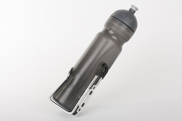 Grey bike water bottle inserted to holder, studio photo, isolated on white background.