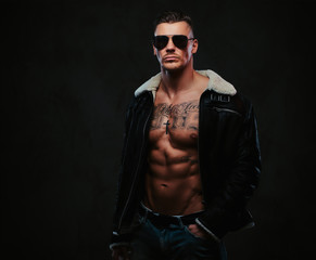 Obraz premium A macho stylish man on a dark background.