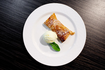 Apple strudel and ice cream on the plate