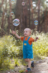 Happy mother baby bubble blower nature concept. Family moments. Sunny day in the forest.