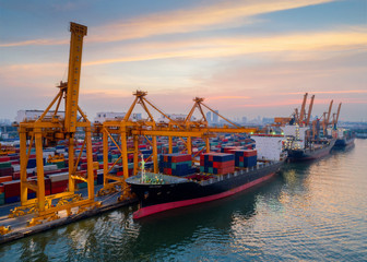 Containers yard in port congestion with ship vessels are loading and discharging operations of the transportation in international port.Shot from drone.