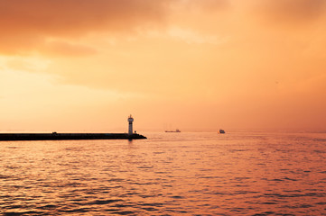 Small lighthouse and beautiful sunset sky on a cloudy day