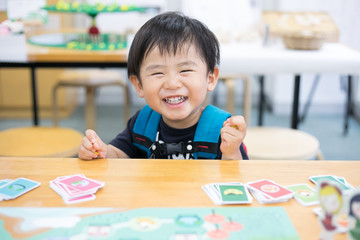 カードゲームで遊ぶ笑顔の子供