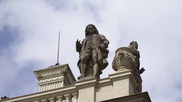 Wolfgang Amadeus Mozart statue Sculpture on roof of the Rudolfinum concert hall in Prague with cloudy sky on background.Timelapse 4kFS5