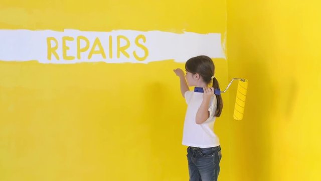 a funny girl with a roller in her hand wrote on the wall an inscription repairs