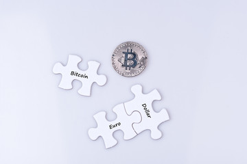 Bitcoin mit Puzzel Stücken auf denen Euro und Dollar steht