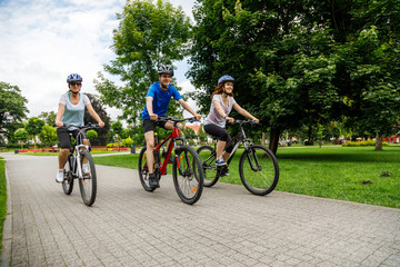 Obraz premium Healthy lifestyle - people riding bicycles in city park 