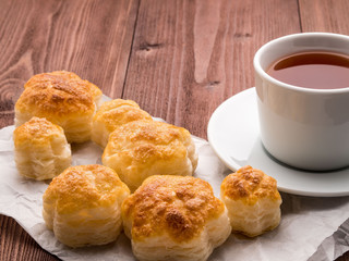 Breakfast with home baking and a Cup of tea on brown wooden table, side view