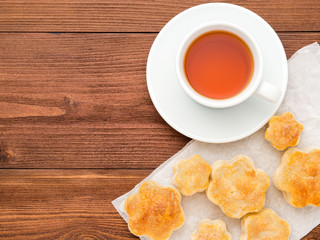 Breakfast with home baking and a Cup of tea on brown wooden table, top view