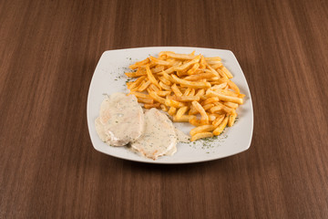 pork chops with white sauce and fried potatoes