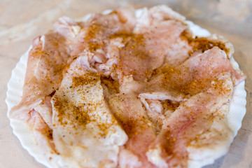 Raw chicken fillet sprinkled with spices