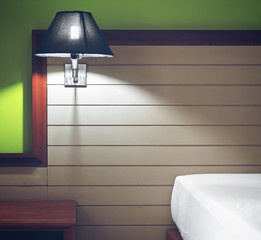 abstract mood lighting or lamp and lantern at brown headboard wood on the white bed and wooden table or nightstand with green wall in the room at home or hotel