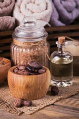 Fototapeta na wymiar Natural cosmetic oil, sea salt and natural handmade soap with cocoa beans on rustic wooden background