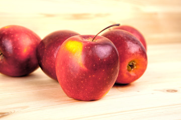 Ripe red apples on wooden background .