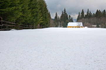 Yellow house in winter forest. Forest ranger house among deep snowdrifts in the forest.