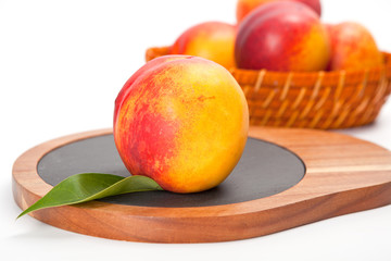Freshly washed peach  on wooden cutting board isolated on white background