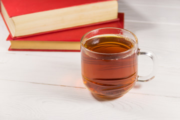 Cup of tea and book on white wooden table