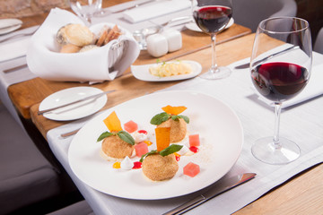 Plum dumplings with cinnamon, white chocolate and vanilla sauce served in a restaurant