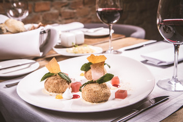 Plum dumplings with cinnamon, white chocolate and vanilla sauce served in a restaurant